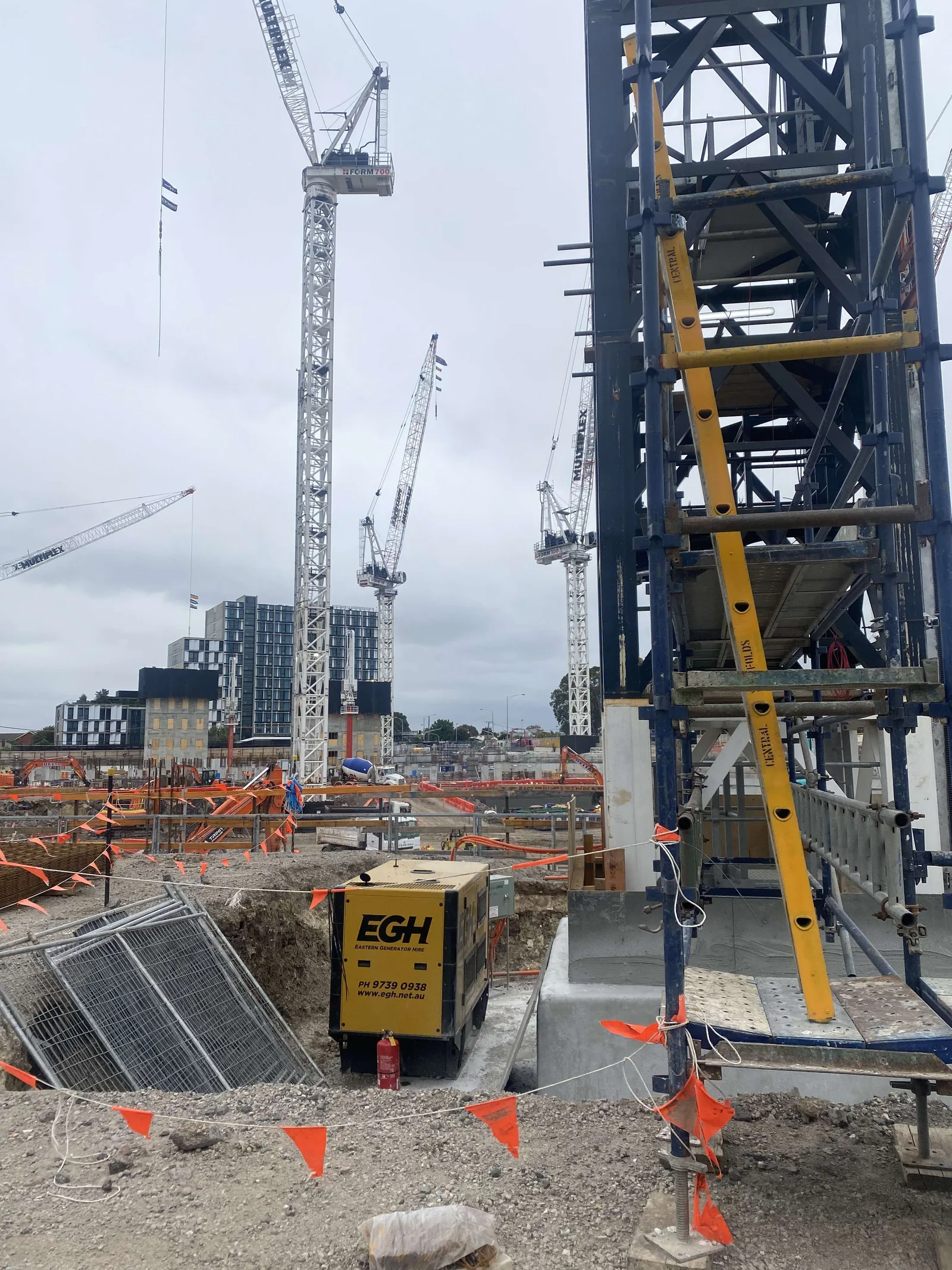 Tower cranes over a construction site running on temporary generator power