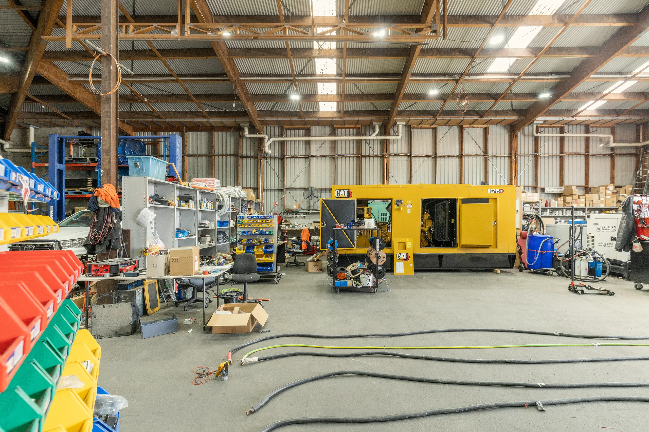 A hire generator standing in an industrial workshop with services run to it