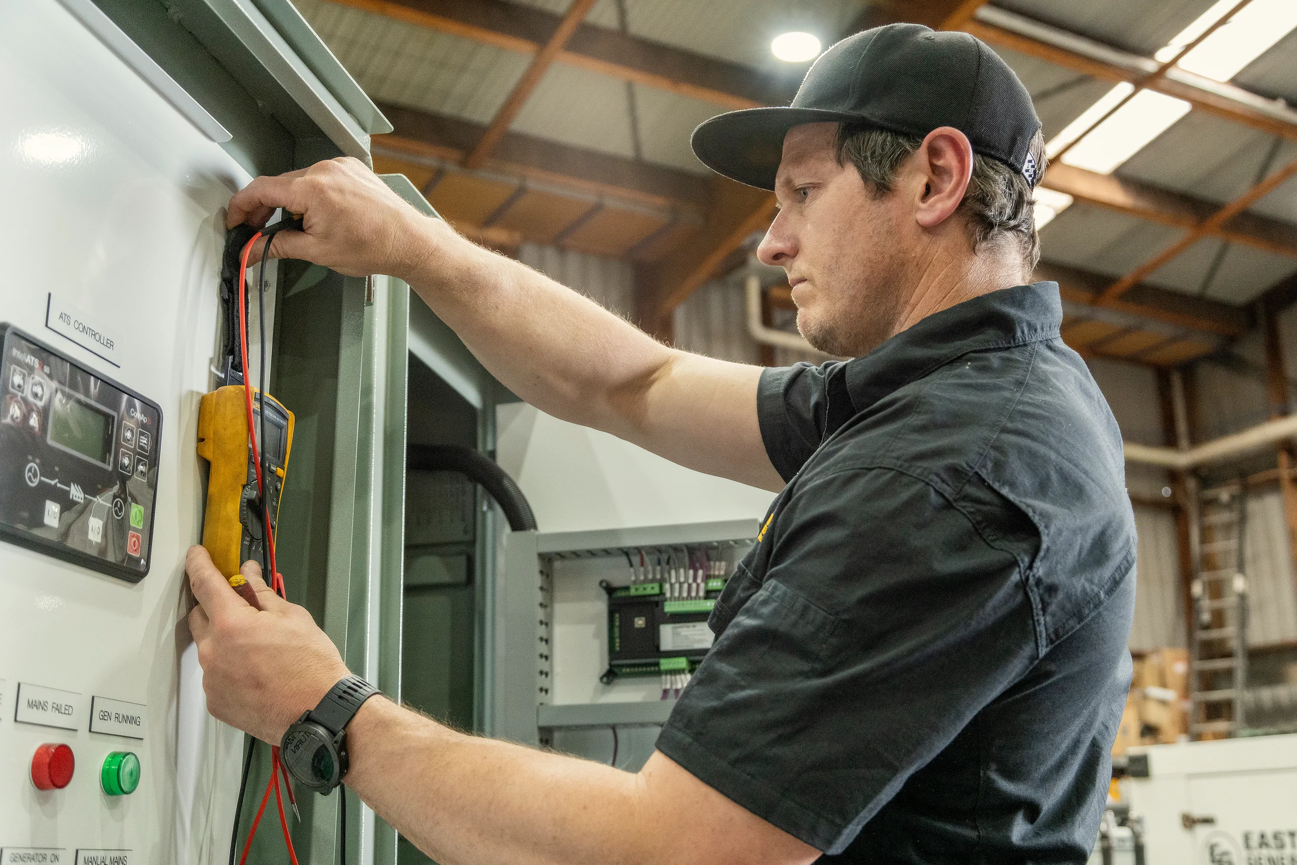 An Eastern Generators technician servicing a yellow diesel generator