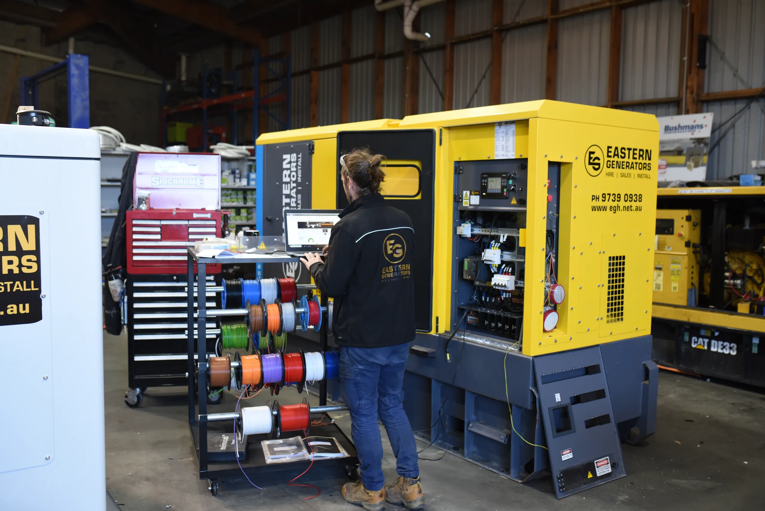 An Eastern Generators technician working inside an open hire generator