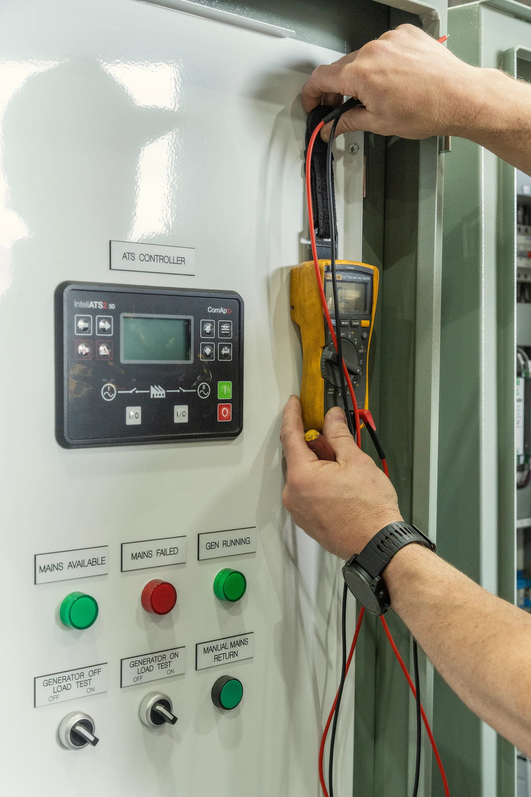 An Eastern Generators technician taking a reading from a generator with a multimeter