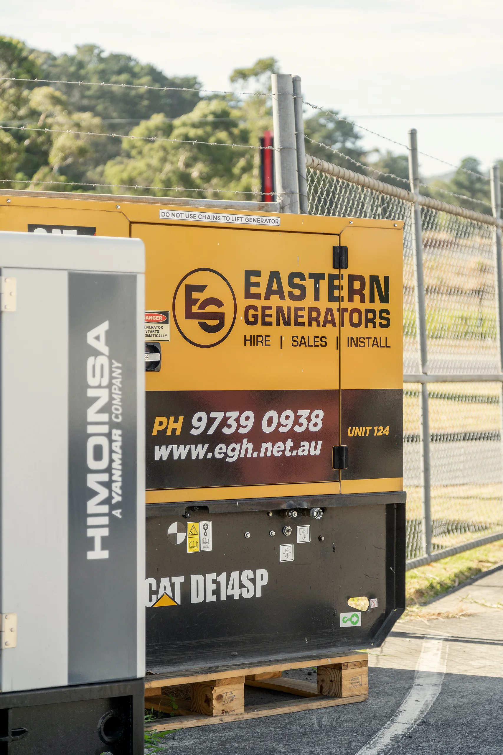 A small Caterpillar hire set in Eastern Generators livery, beside a Himoinsa unit in the Kilsyth yard
