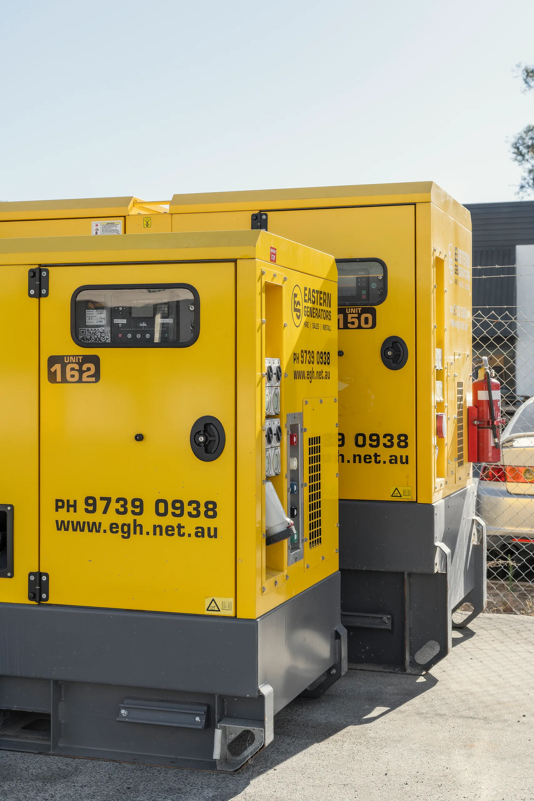 Two canopied Eastern Generators hire sets standing side by side in the yard